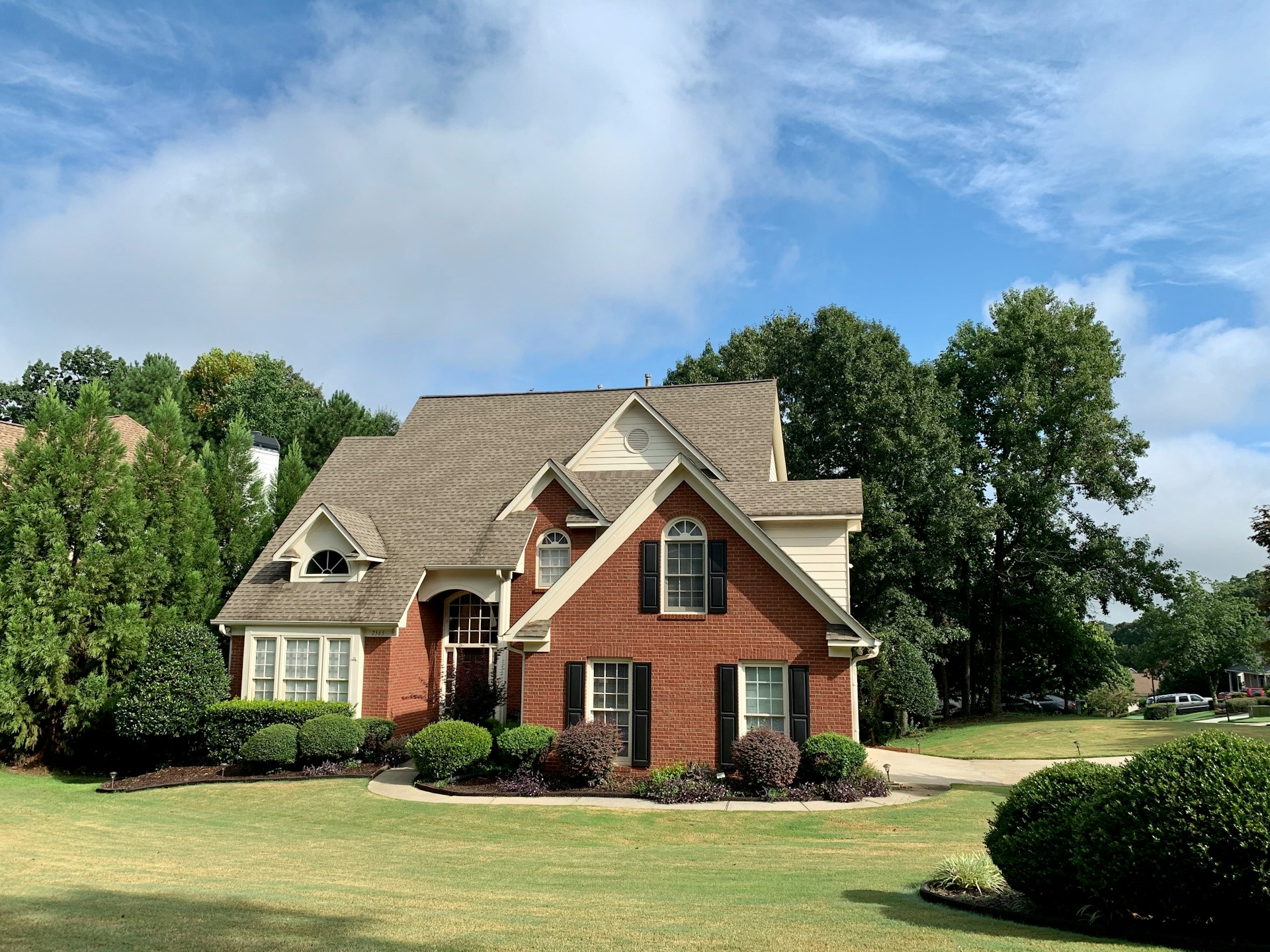 Brick house surrounded by trees. Image by Unsplash.