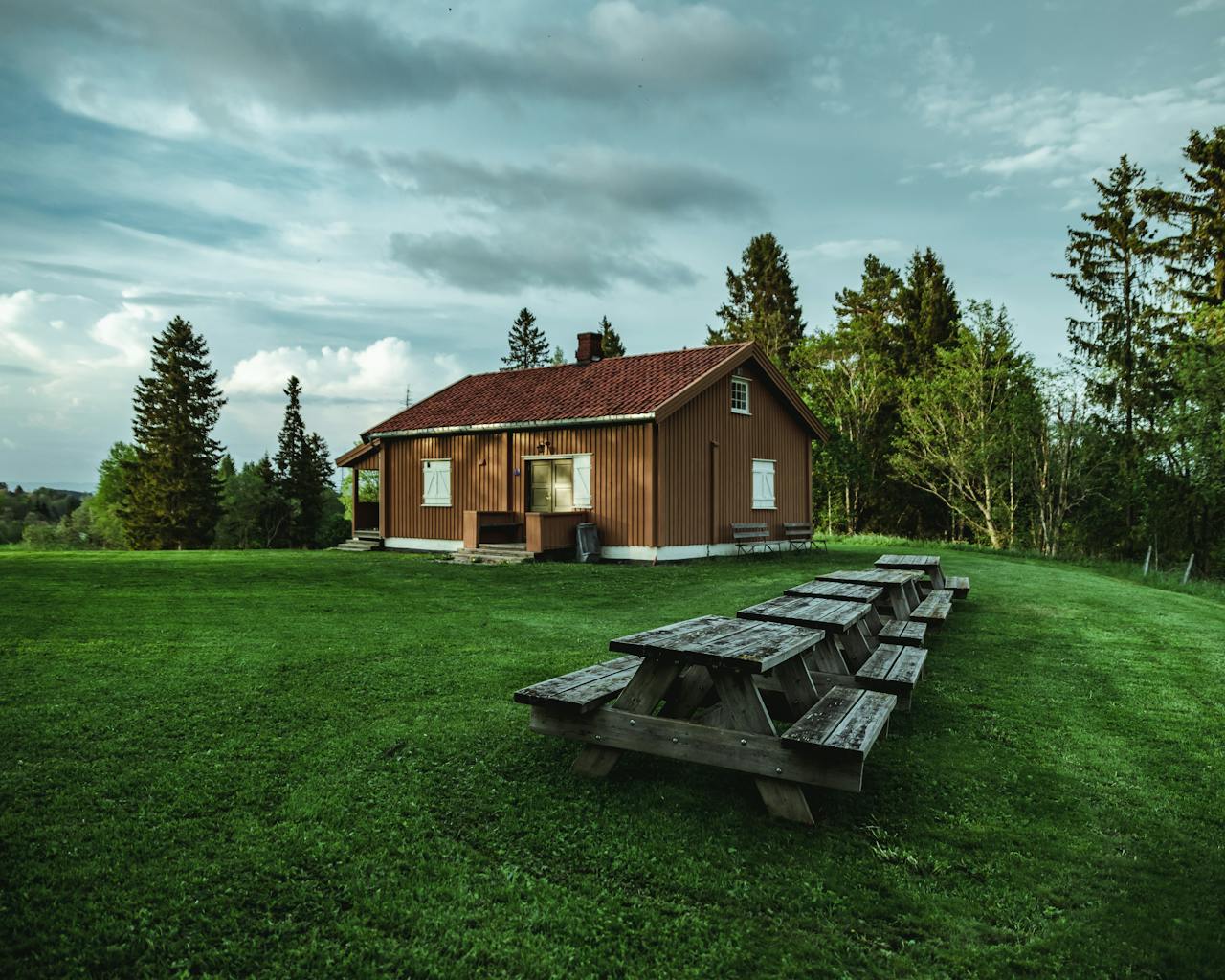 Brown wooden house near trees. Seating areas. Image by Pexels
