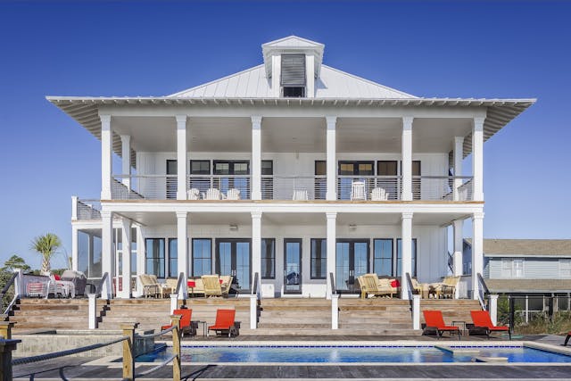 white house, pool, red chairs. Image by Pexels