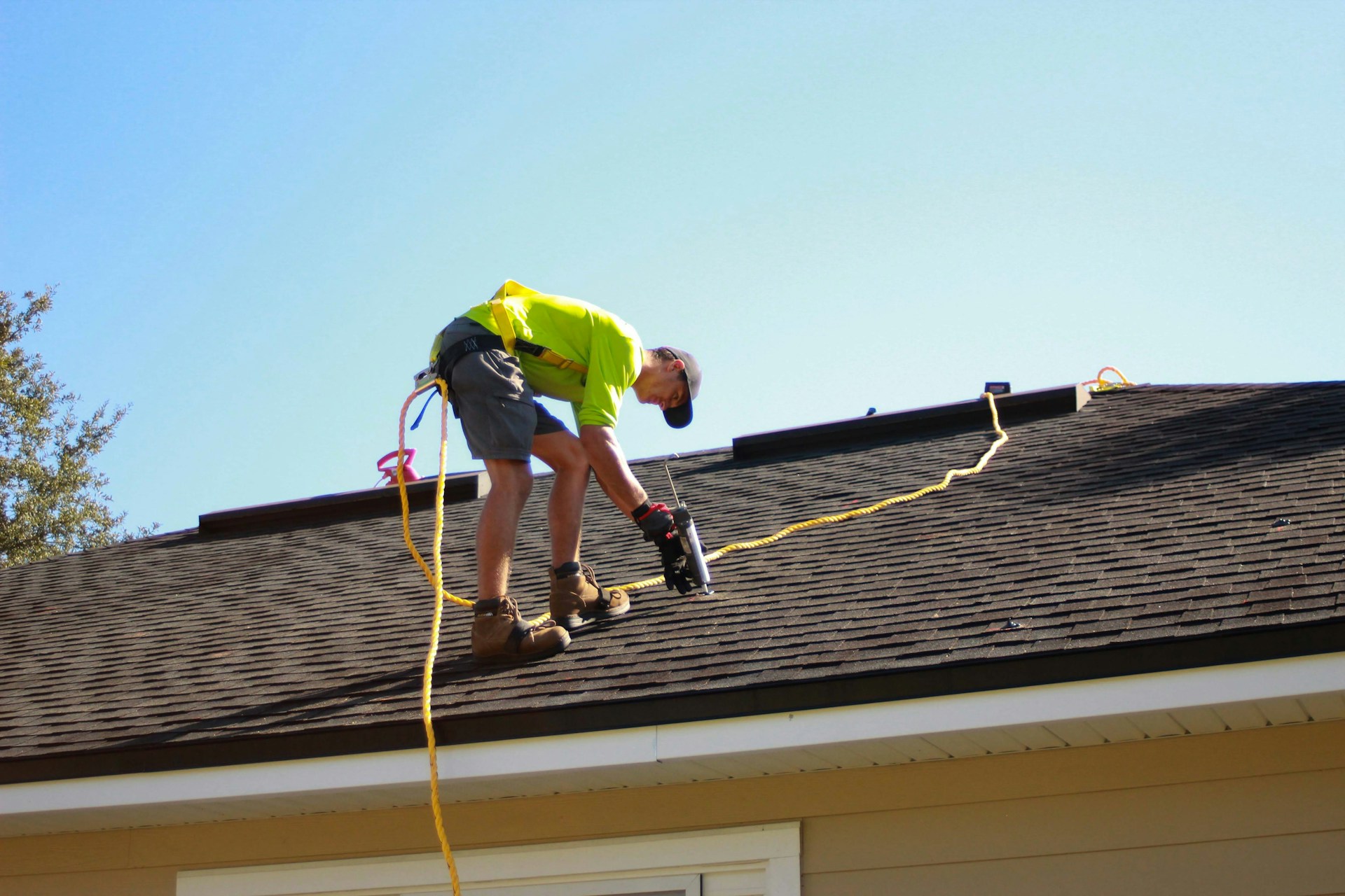 Person working on a roof with a power drill. Image by Unsplash