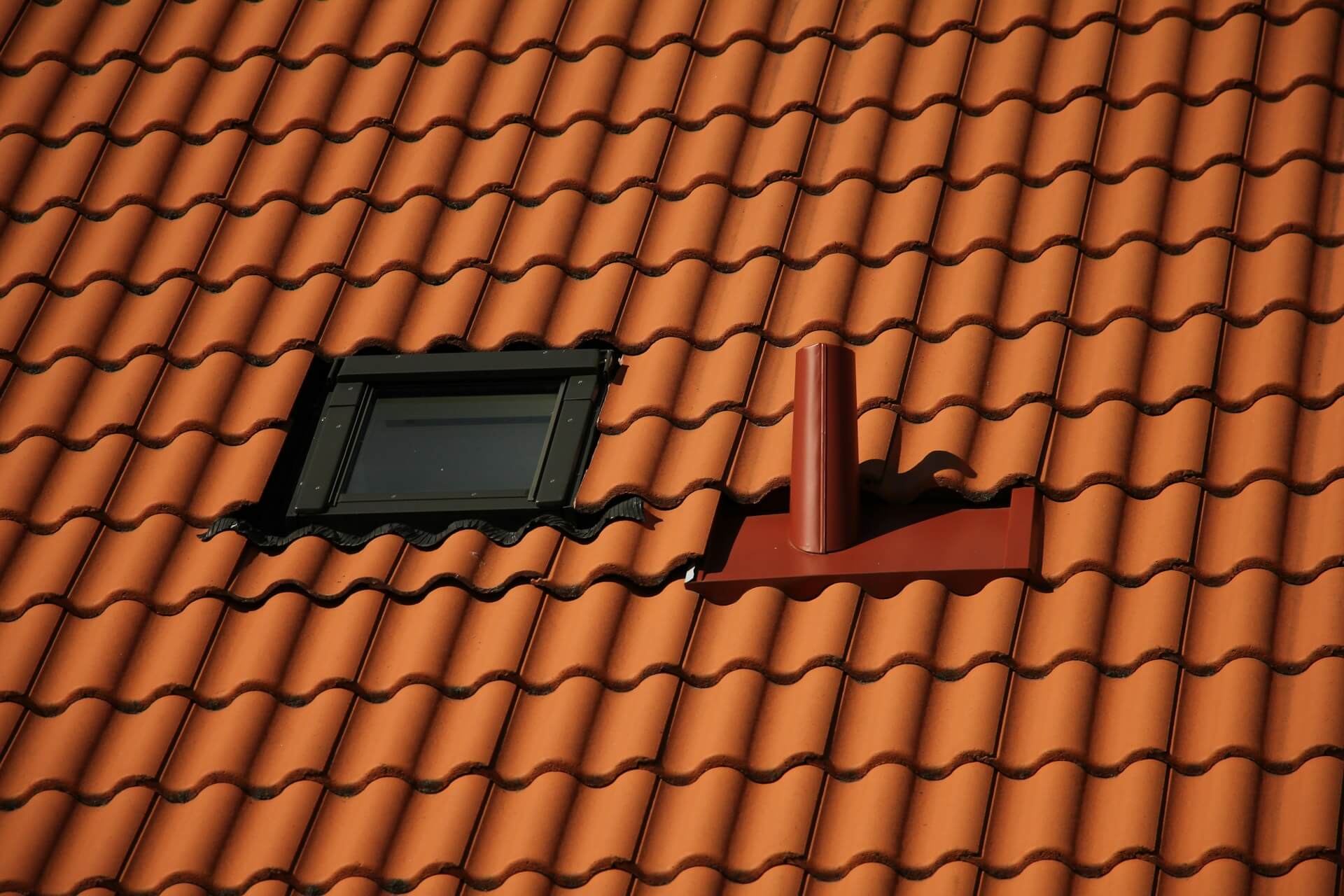 Roof with window and a ventilation pipe. Image by Unsplash