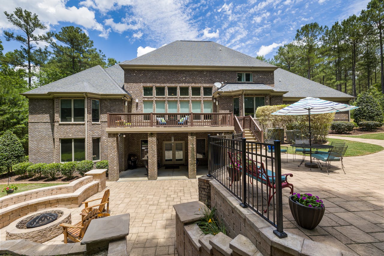 Modern single-family villa with a fire pit in the yard showing curb appeal and intact roofing during a real estate viewing. Image via Pexels