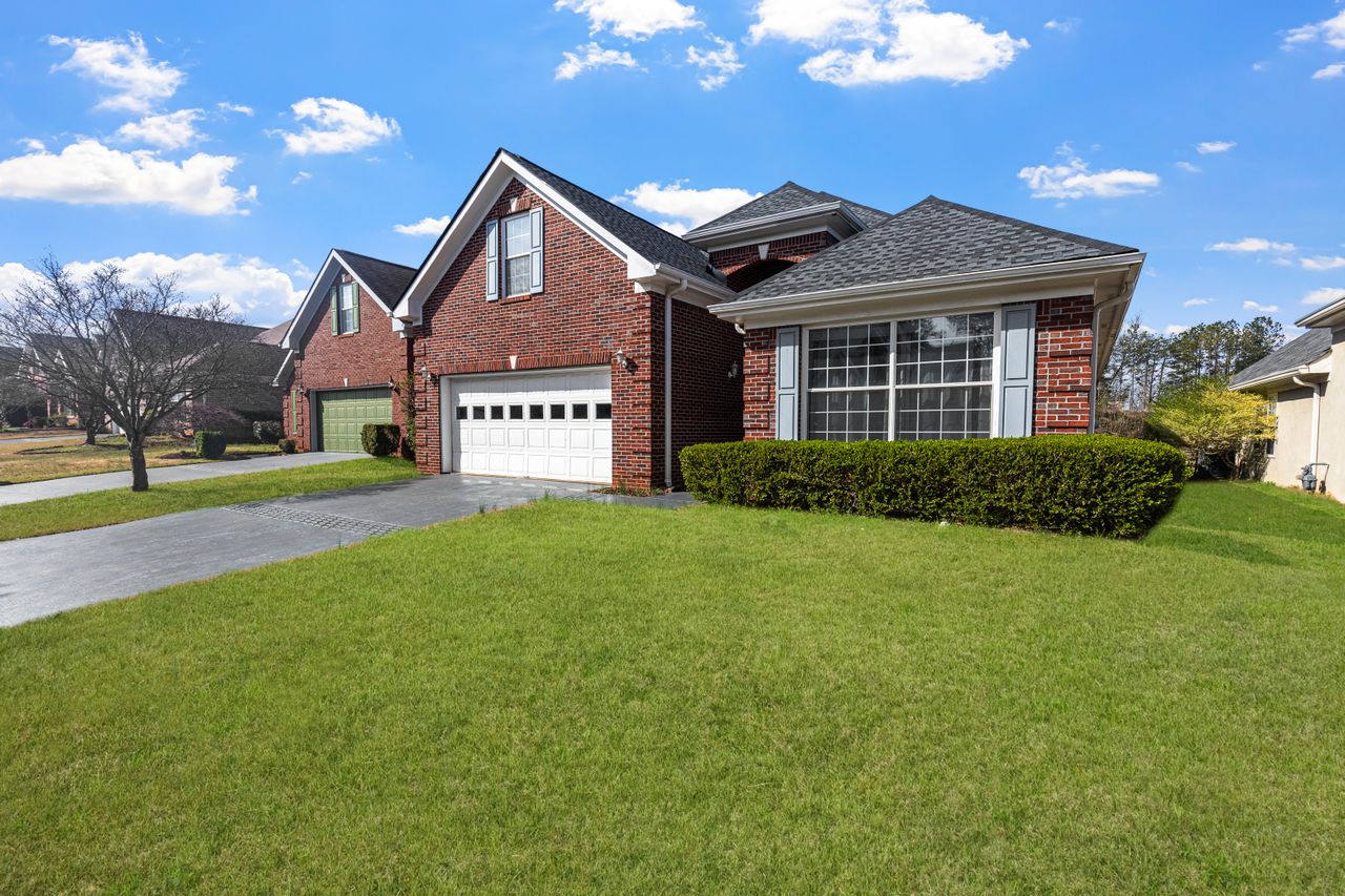 Charming red brick suburban home in daylight showing a well-maintained roof during the closing of a real estate transaction. Image via Pexels