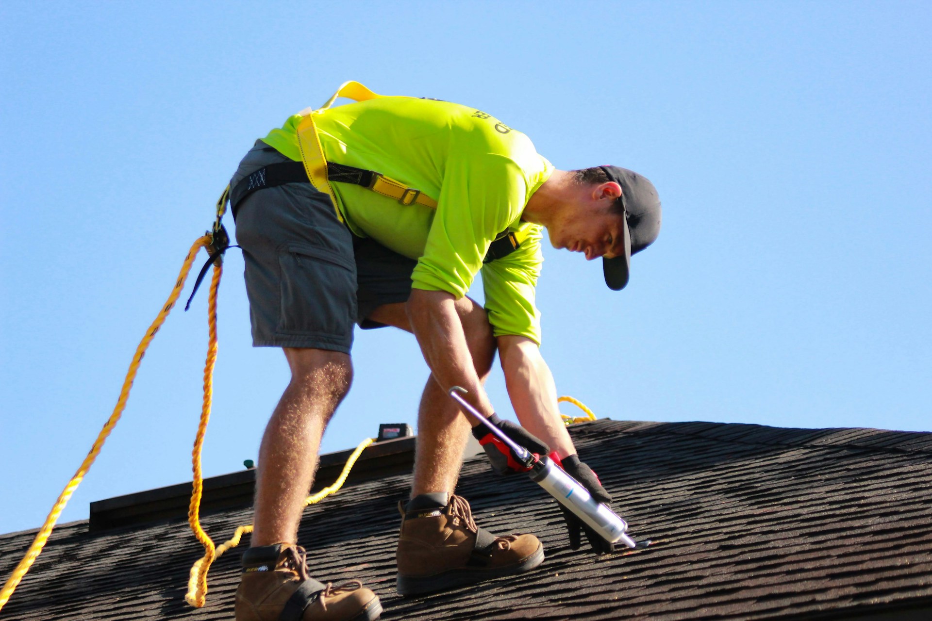 Person in a yellow shirt working on a roof. Image by Unsplash