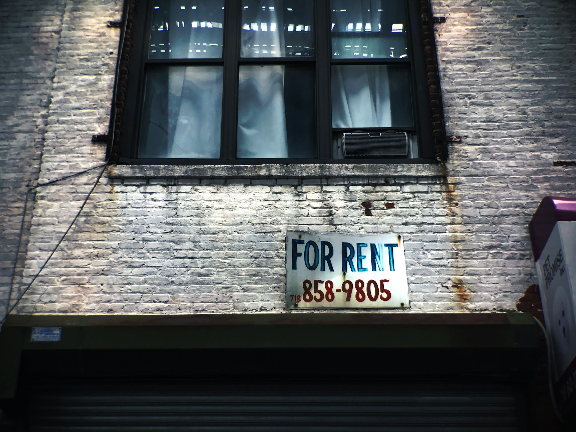 Brick house with a for sale sign. Image by Unsplash