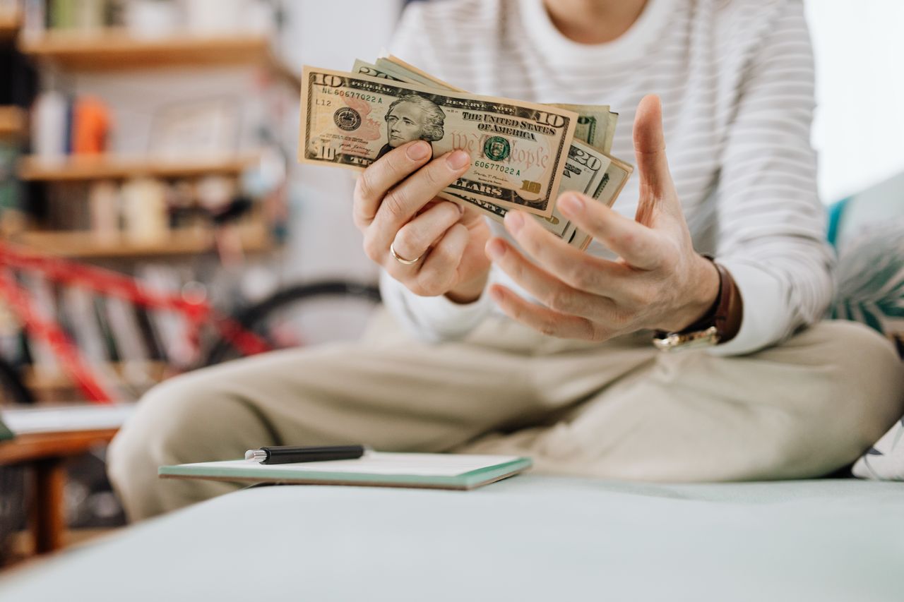 Person holding cash in their hands. Photo via Pexels