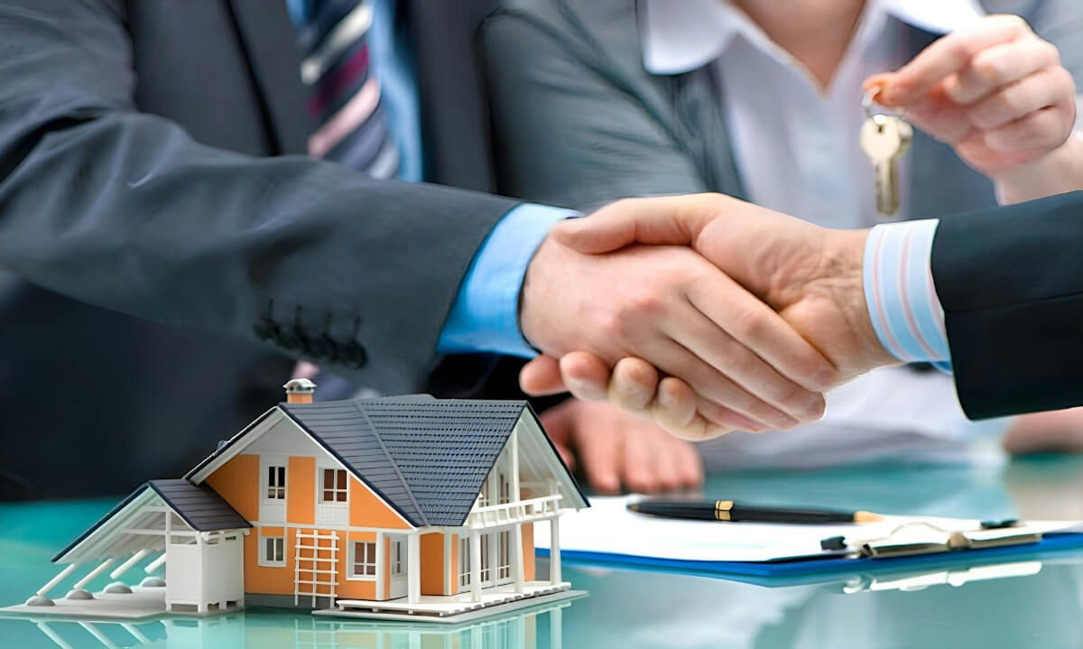Two men shaking hands over a house model and keys. Image by Unsplash