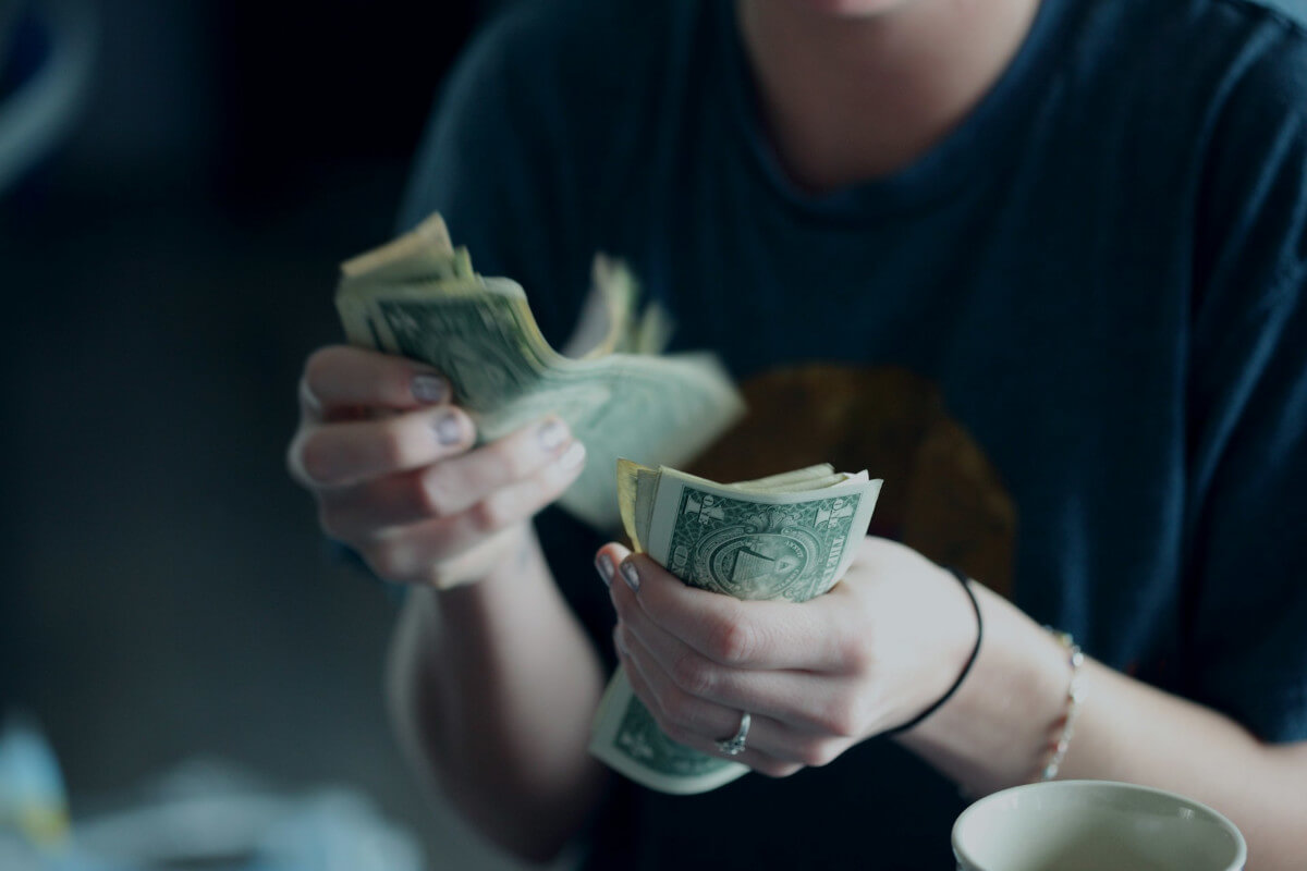 Person counting dollar banknotes. Image by Unsplash
