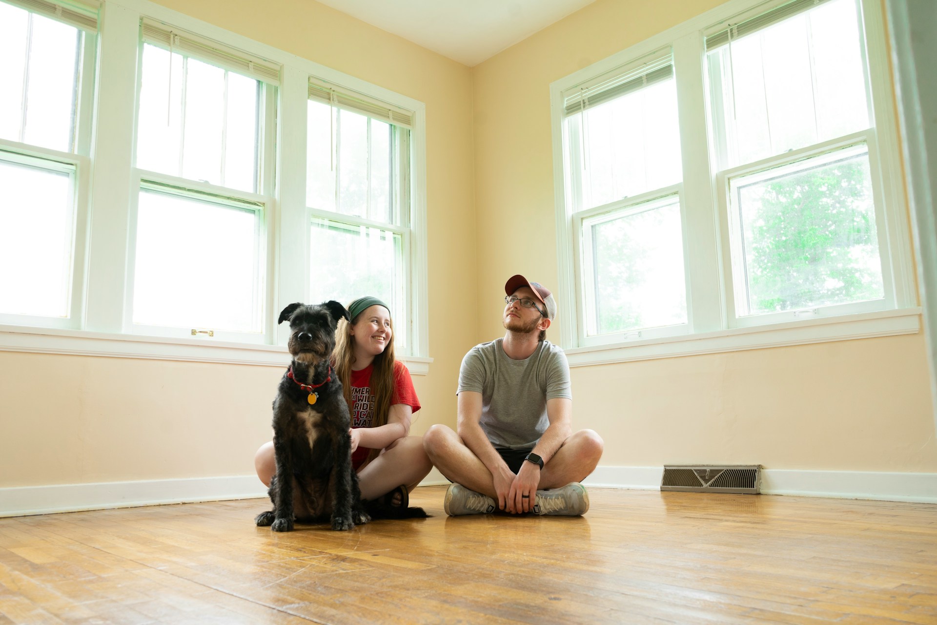 2 people and a dog sitting in an empty room. Image by Unsplash