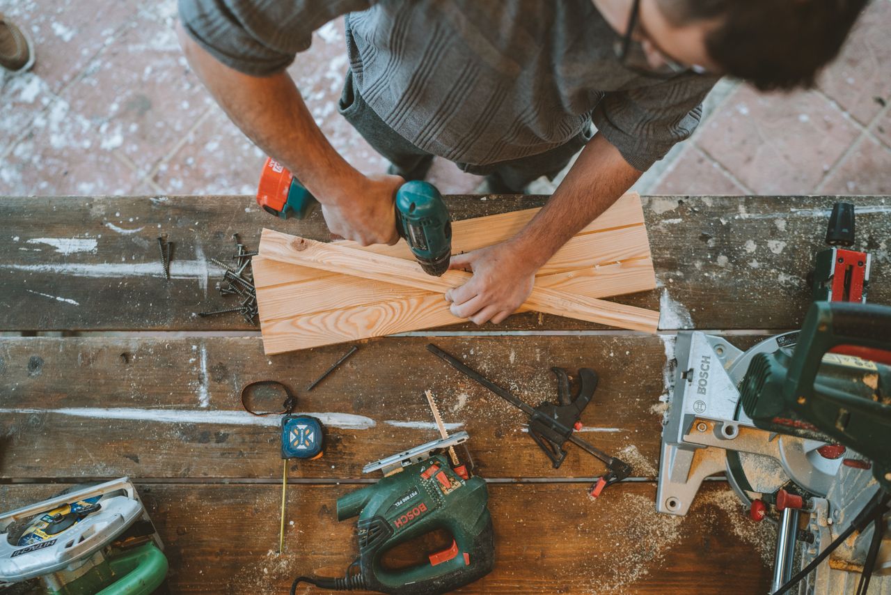 A man drilling a hole in wood during a home repair. Image by Pexels
