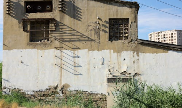 Worn-down house with peeling paint and overgrown grass sold as-is to a cash buyer. Image by Pexels