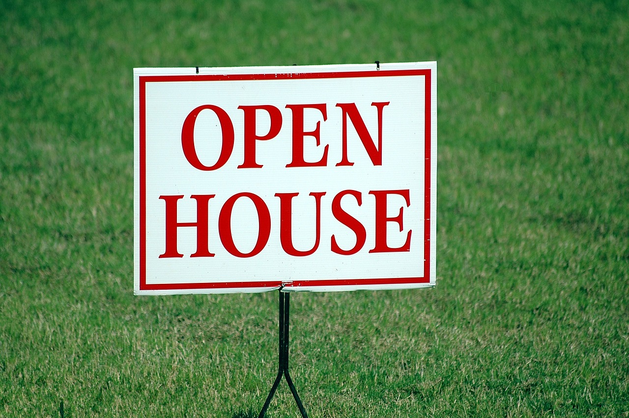 Open house sign on a green lawn. Image by Pixabay