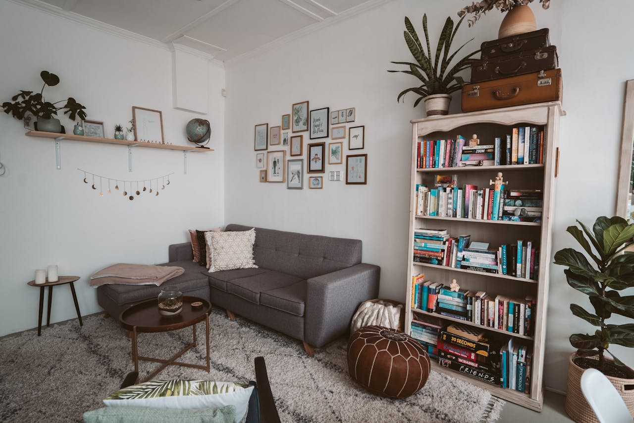Livingroom with gray sofa, bookshelf, art on wall. Image by Pexels