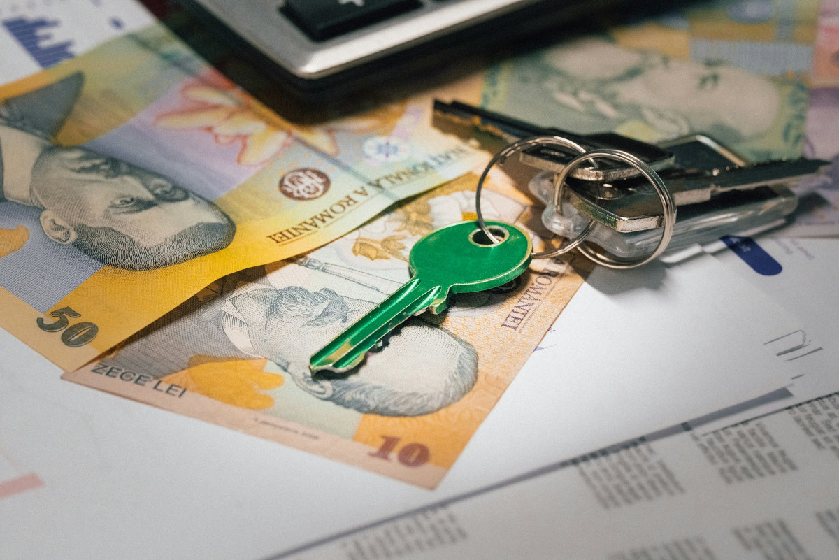 Cash, paperwork and keys on a table. Image by Unsplash