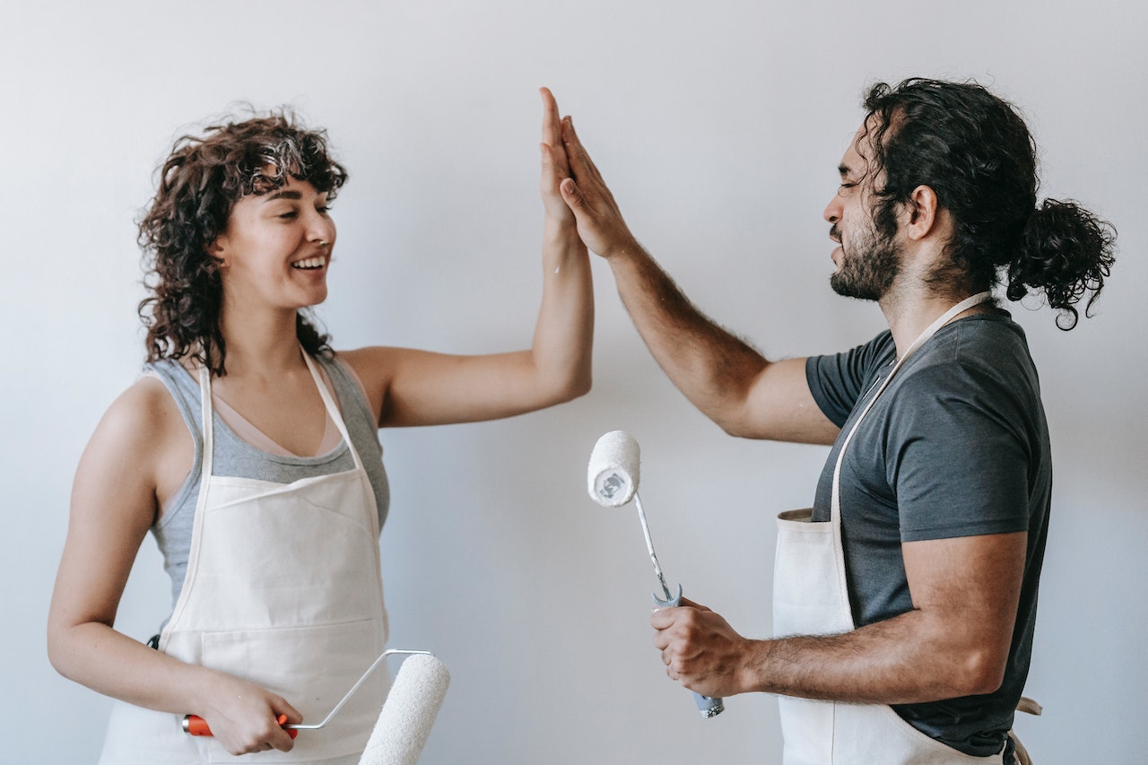 people holding paint rolls in their hands