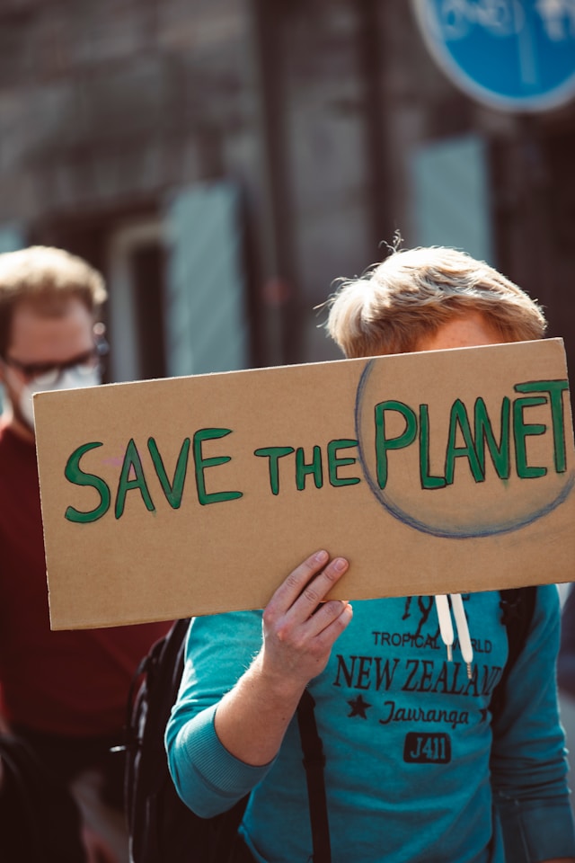 Person with a sign that says SAVE THE PLANET. Image by Unsplash