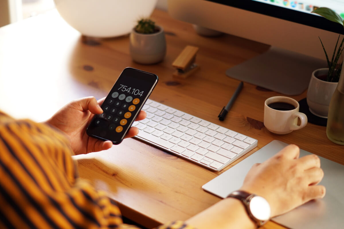 person working on from home doing calulations on a phone