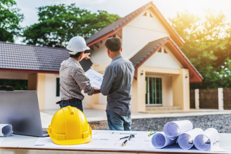 Two people pointing to a house