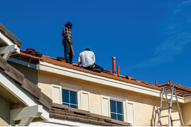 2 people repairing a roof