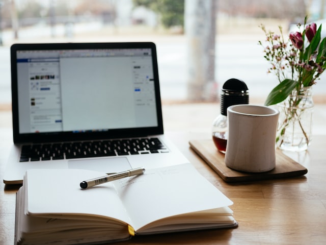 Laptop, notebook, pen, coffee cup