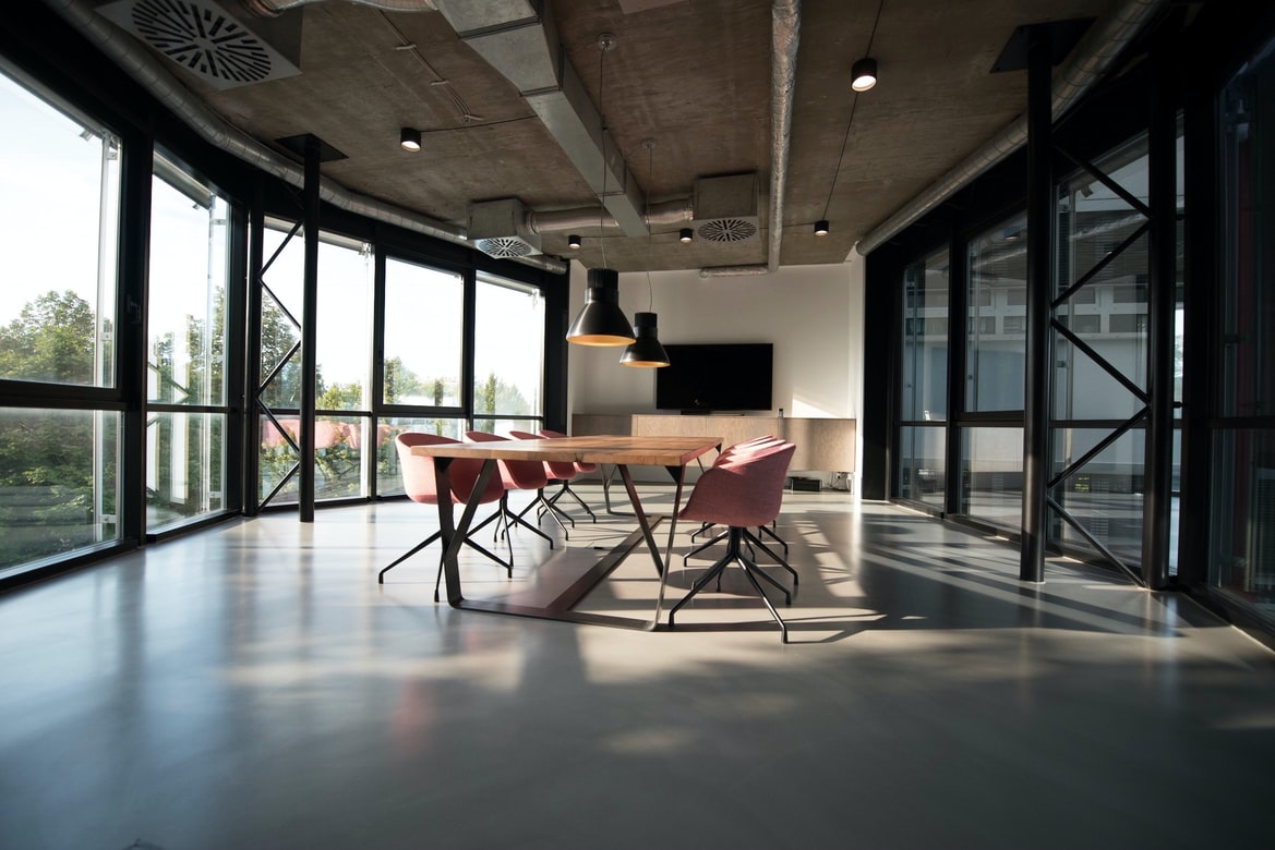 table and chairs in a large room, lots of windows