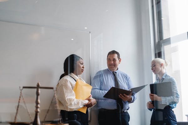 3 people talking in a law office