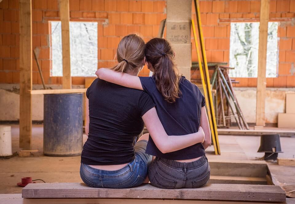 2 people holding arms around each other, contruction site