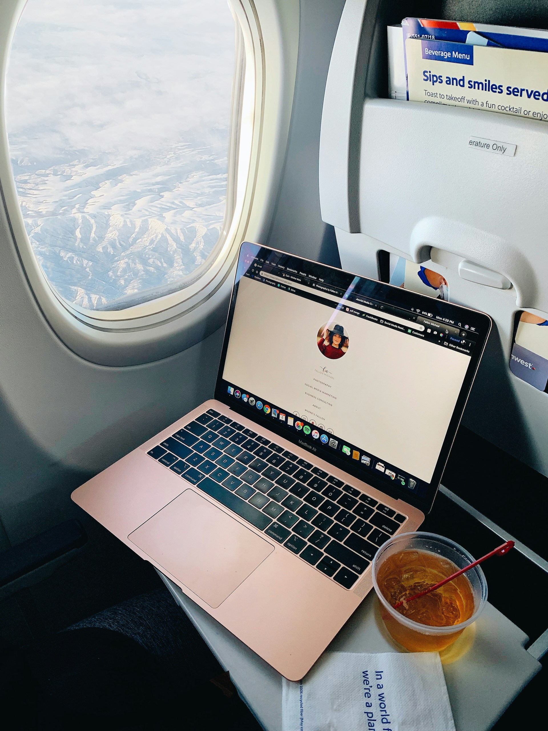 airplane window, laptop, drink. Image by Unsplash
