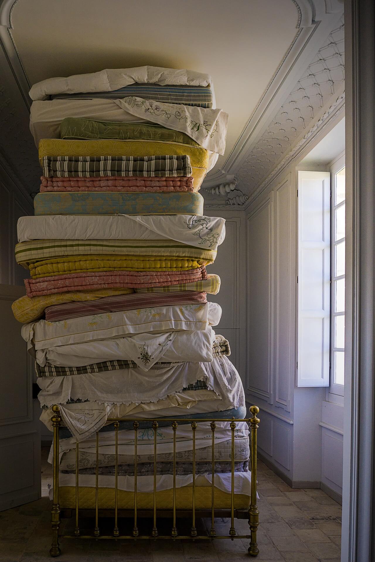 a pile of old mattresses on a bed
