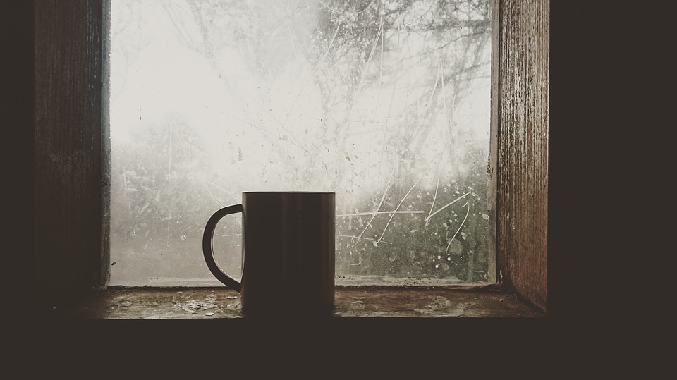 Coffee mug in front of a window. Cold weather outside.