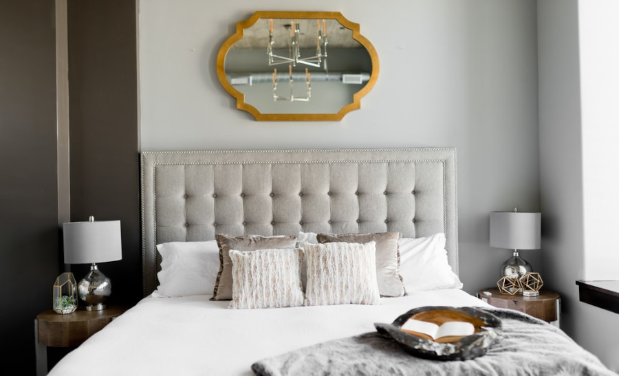 Tufted white bed near a window