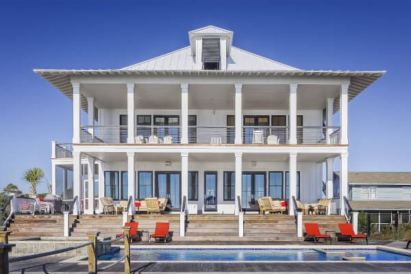 White house with large patio and pool